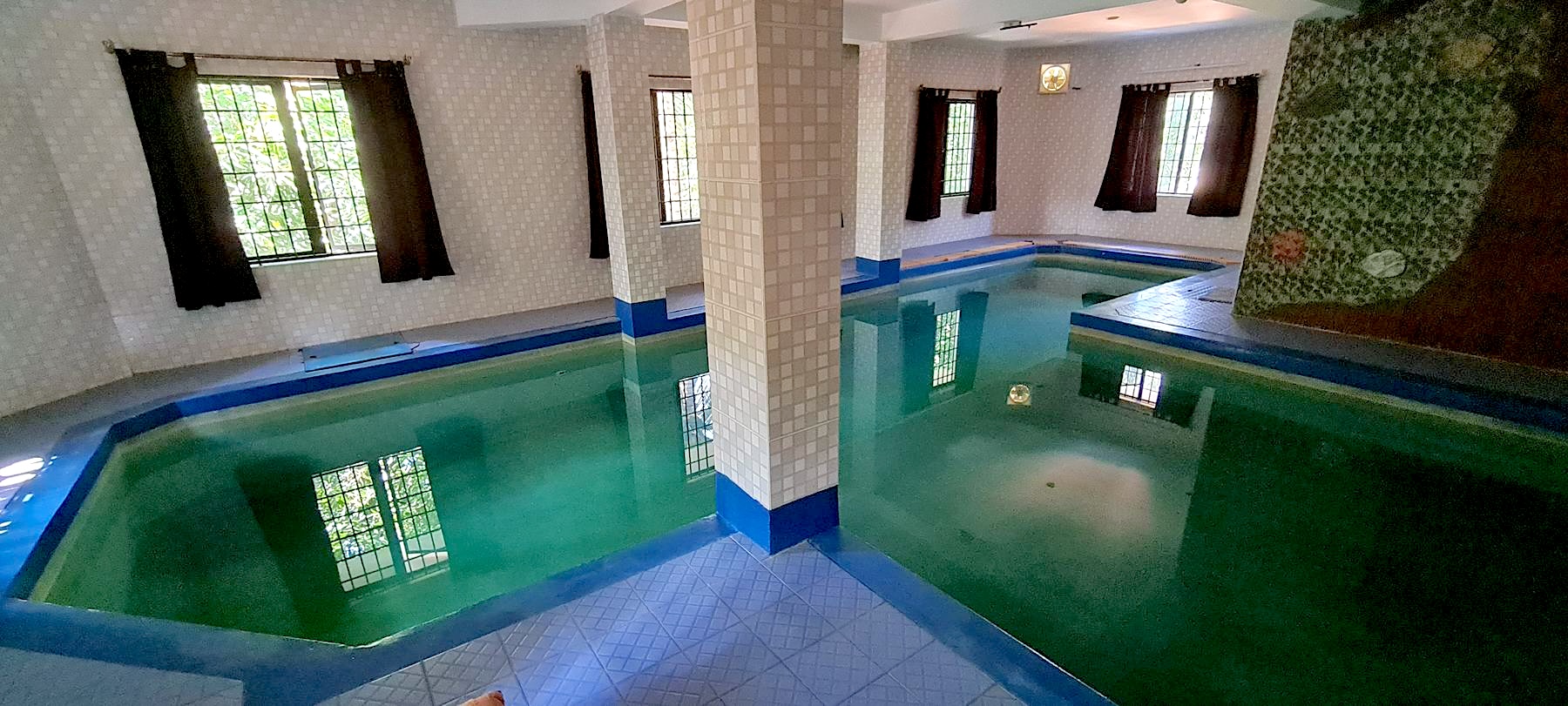 The indoor swimming pool on the first floor, with tiled columns and windows along one wall